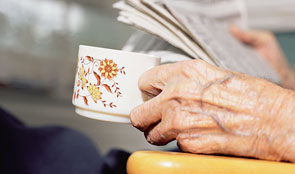 Elderly hand holding a cup